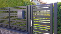 černý moderní kovový plot s hliníkovou výplní a originálními kovovými sloupky