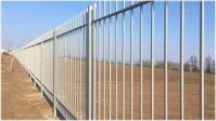 kovový plot pro ochranu průmyslové zóny, který je tvořen průnikem vodorovných a svislých prvků