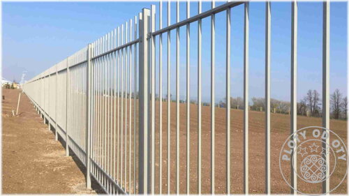 kovový plot pro ochranu průmyslové zóny, který je tvořen průnikem vodorovných a svislých prvků