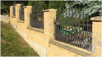 kovový plot černé barvy se zhuštěnými dutými prvky ve spodní části plotového dílce