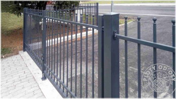 jednoduchý kovový plot bez doplňkového zdobení s vjezdovou dvoukřídlou bránou, vše opatřené antikorozní vrstvou a šedou vrchní barvou
