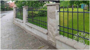 černý jednoduchý kovový plot za lidovou cenu, umístěný mezi zděné sloupky z štípaného betonu
